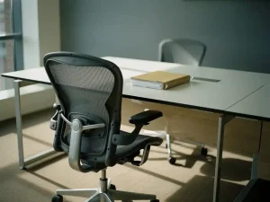 Leeg ergonomisch bureaustoel voor een modern bureau met gesloten personeelsdossier, zacht natuurlijk licht in een Nederlands kantoor.